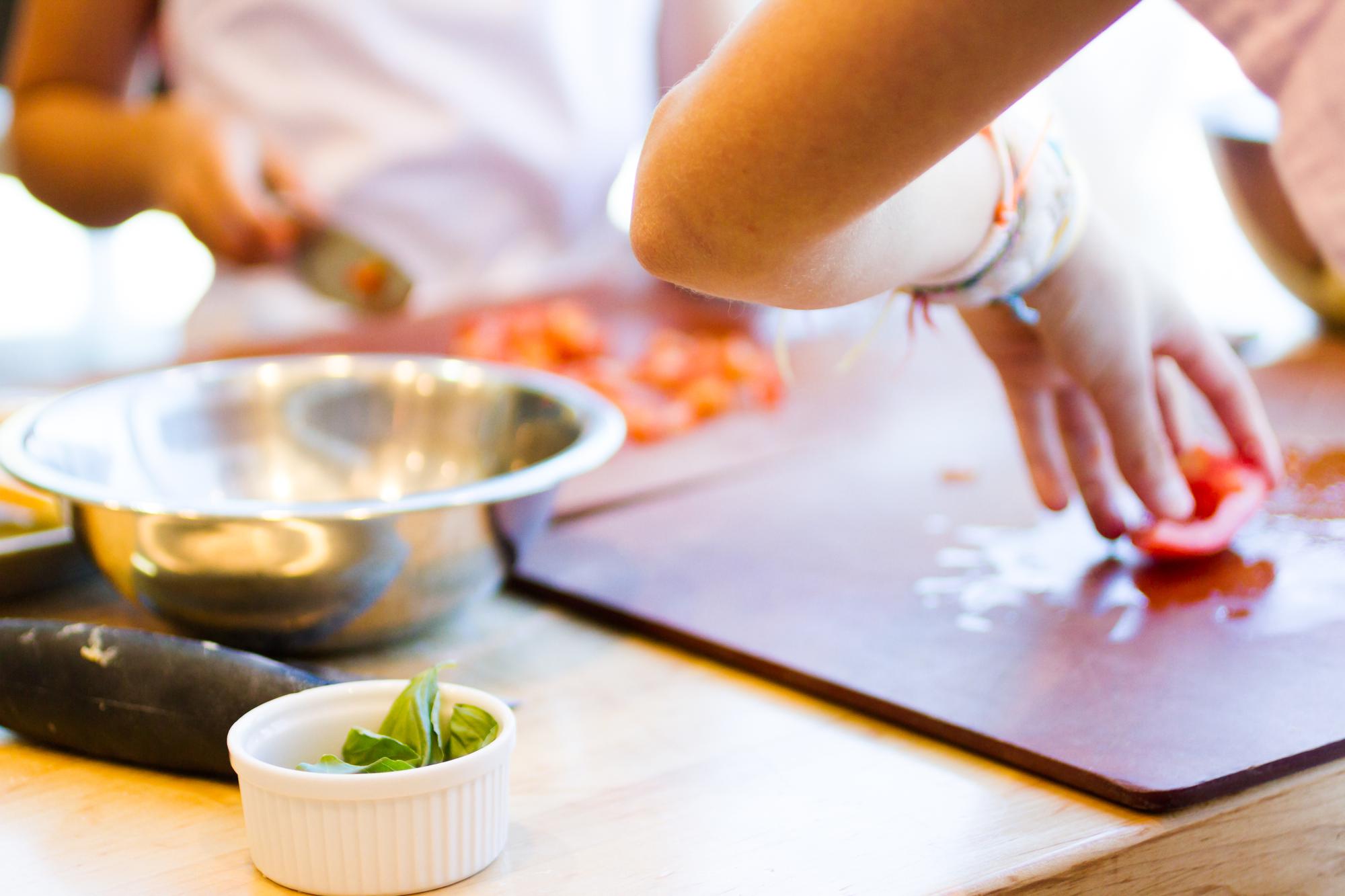 Student practicing sauce technique in studio kitchen