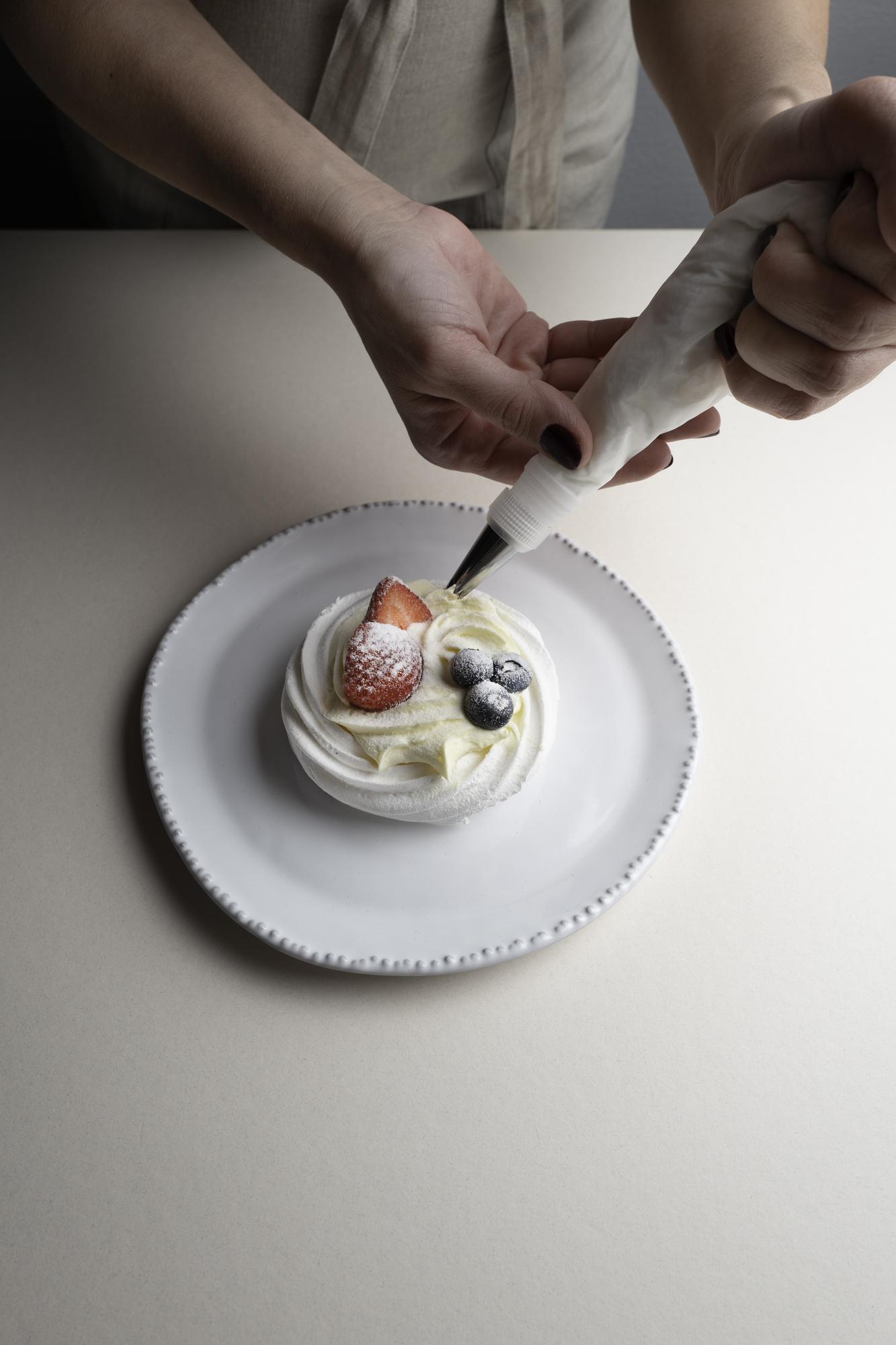 Close-up of hands plating a dessert